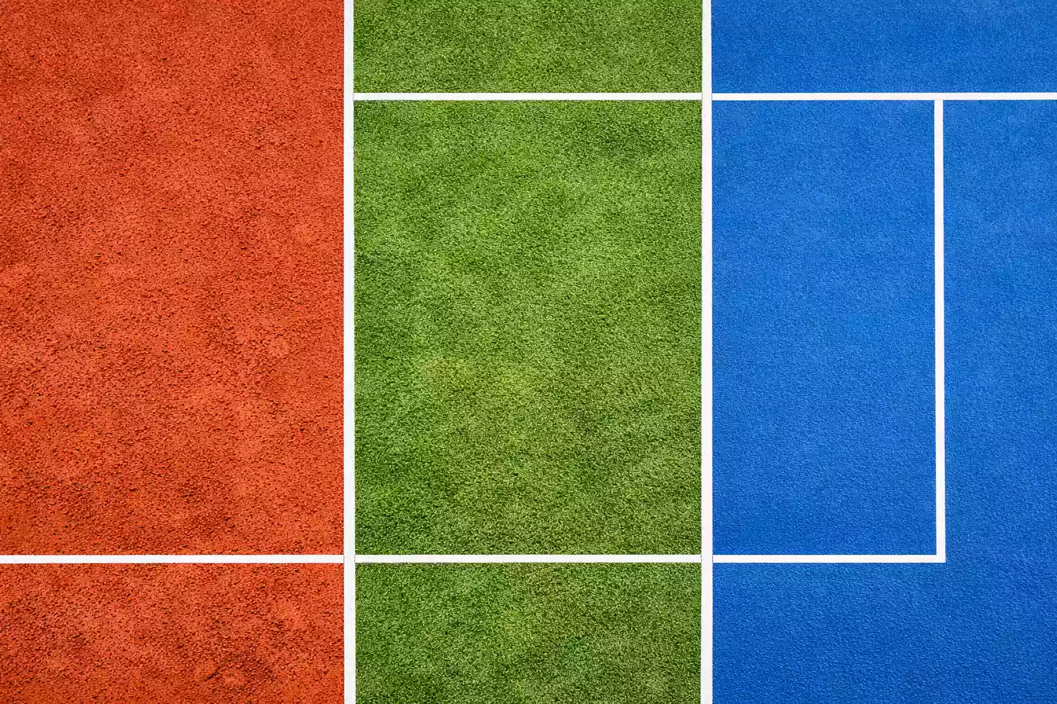 Drie verschillende tennisondergronden naast elkaar: gravel, gras en hardcourt