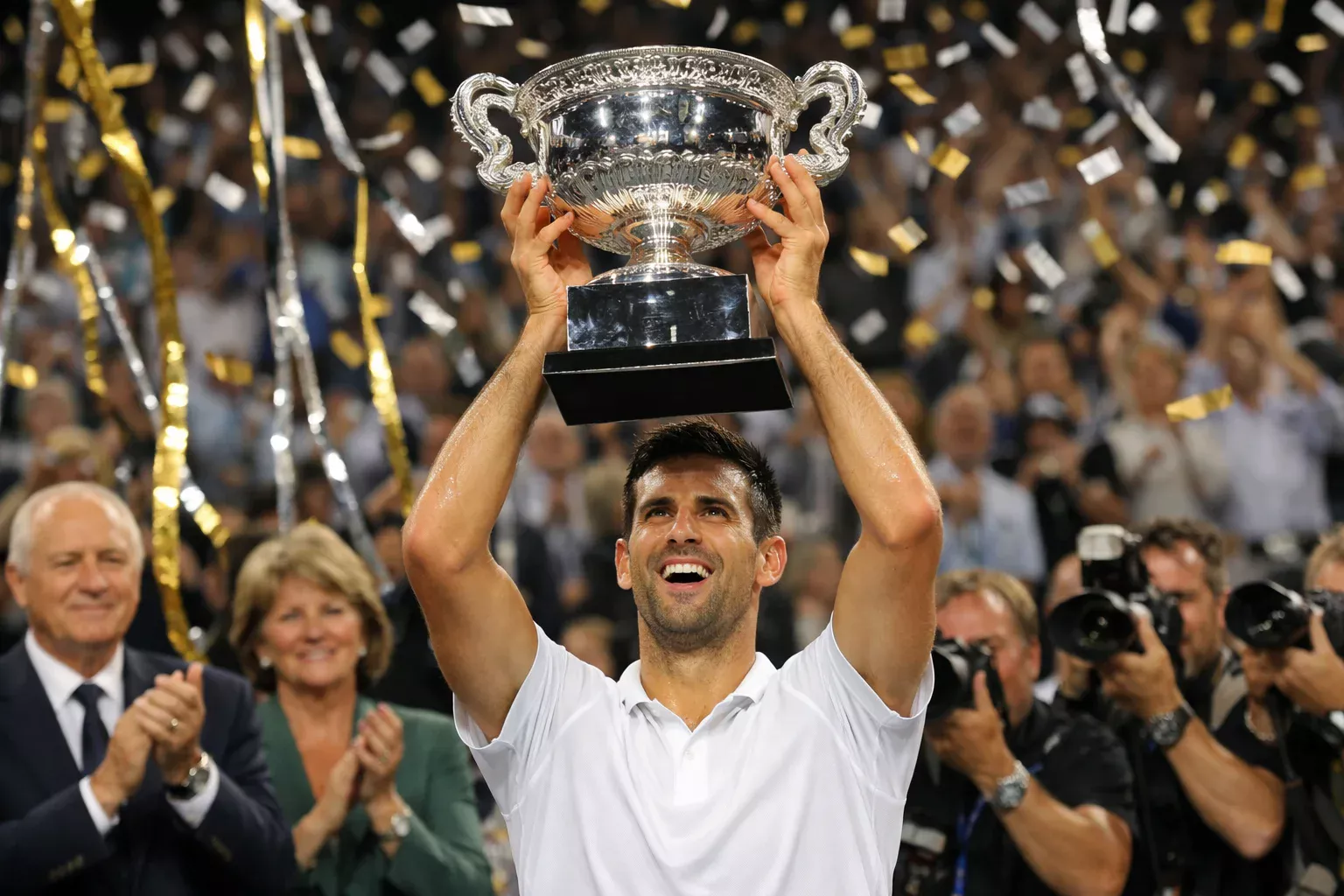 Tenniskampioen houdt Grand Slam trofee omhoog tijdens prijsuitreiking